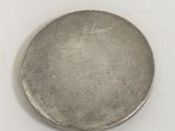 an old silver coin on a white surface