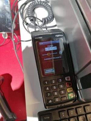 un téléphone portable posé sur un bureau, à côté d'un clavier