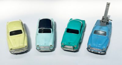 plusieurs petites voitures sont alignées sur une surface blanche