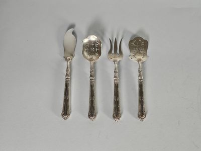 trois fourchettes et cuillères sont posées sur une surface blanche