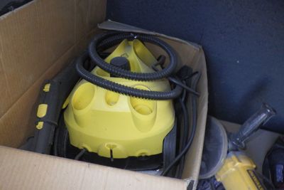une boîte contenant un aspirateur jaune et un tuyau noir