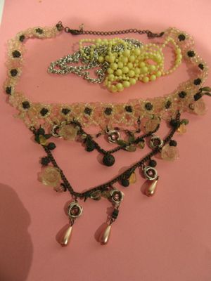 a picture of a necklace with beads and charms on it