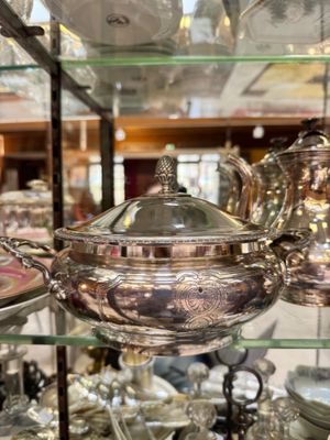 a display case with a lot of silver dishes