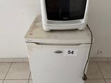 a microwave sitting on top of a refrigerator in a room