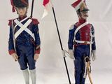pair of figurines of two soldiers with flags on wooden bases