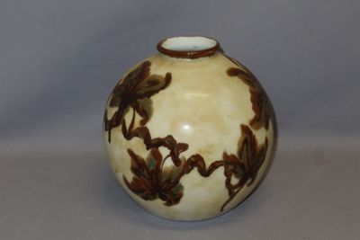 un vase blanc orné de motifs marron, posé sur une table