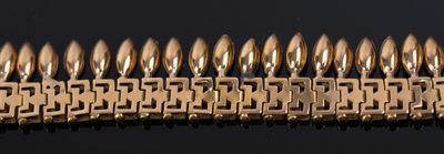 an image of a row of gold bracelets on a black surface