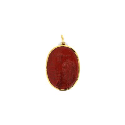 un pendentif en or avec une pierre rouge au centre