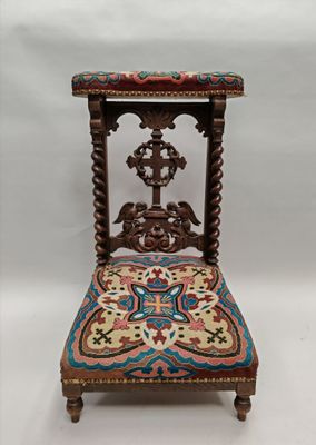 une chaise ancienne en bois dont l'assise est recouverte d'un tissu coloré sur fond blanc