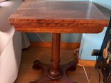 a small table with a wooden top on a hard wood floor