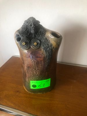 un petit vase orné d'un hibou, posé sur une table