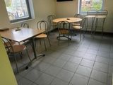 des tables et des chaises dans une pièce où une télévision est accrochée au mur