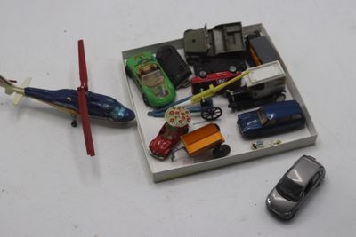 une petite boîte contenant des petites voitures et un hélicoptère miniature
