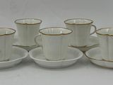 many cups and saucers sitting on a white table