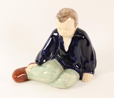 a figurine of a man sitting on the ground