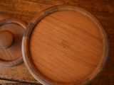a wooden bowl with a lid sitting on a table