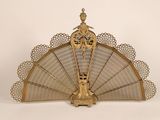un ventilateur ancien en laiton orné d'un motif décoratif sur le dessus