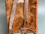 an old leather bag with a strap hanging from it ' s side