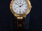 an image of a gold wrist watch with a white dial