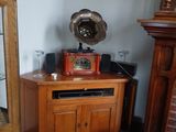 une armoire en bois avec une porte vitrée et une horloge posée dessus