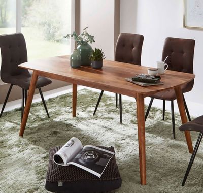 une table en bois avec des chaises et un magazine posé dessus