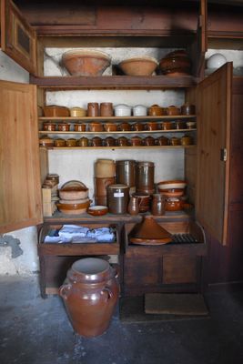 many pots and pans on the shelves in this kitchen
