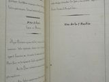 an open book with black writing on it sitting on top of a table