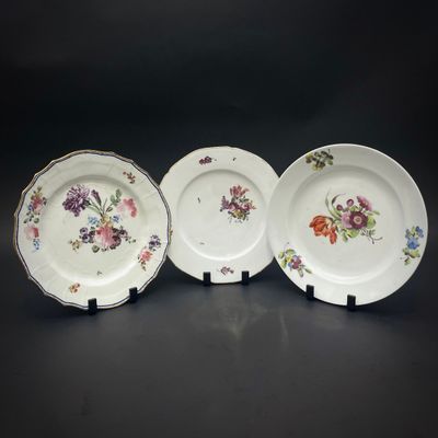 trois assiettes à motifs floraux posées sur une table