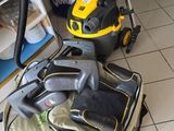 un aspirateur jaune et noir posé sur un sol carrelé blanc