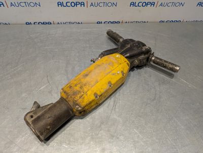 un gros plan d'un marteau jaune et noir posé sur une surface métallique
