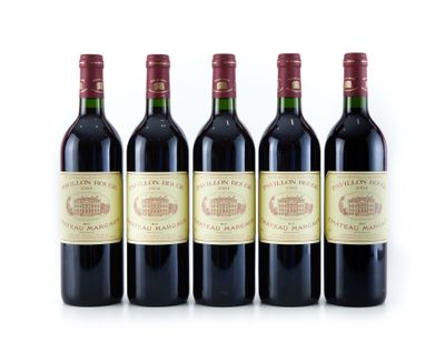 quatre bouteilles de vin sont alignées sur une surface blanche