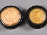 two gold coins with a portrait of a man and a woman on them
