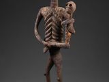 une statue représentant un squelette tenant un bébé dans ses bras