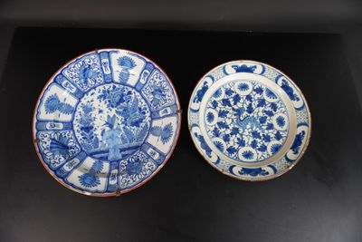 deux assiettes bleues et blanches ornées de motifs, posées sur une surface noire