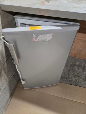 un réfrigérateur qui se trouve dans le coin d'une pièce