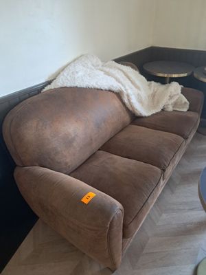 un canapé marron recouvert d'une couverture dans un salon