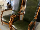 deux fauteuils en cuir vert dans une pièce équipée d'une table et de chaises