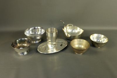 silver plated dishes and cups on a table with a spoon