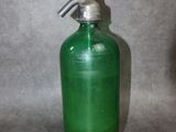 une bouteille en verre vert munie d'une pompe métallique sur le goulot
