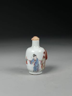 a white and red glass snuff bottle with a woman holding a fan