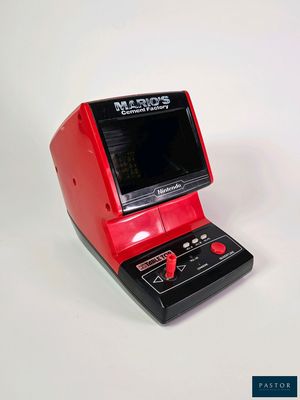 un appareil électronique rouge et noir posé sur une surface blanche