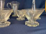 four glasses and a pitcher sitting on a table
