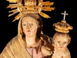a statue of a woman holding a baby and a cross