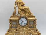 l'image d'une horloge en or sur laquelle est assise une femme