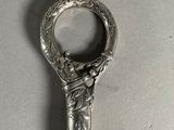 une cuillère en argent avec un manche en bois posée sur une table