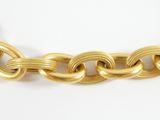a close up of a gold chain necklace on a white surface