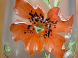 a vase with a flower painted on it on a table