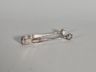 une paire de cuillères anciennes en argent posées sur une surface blanche