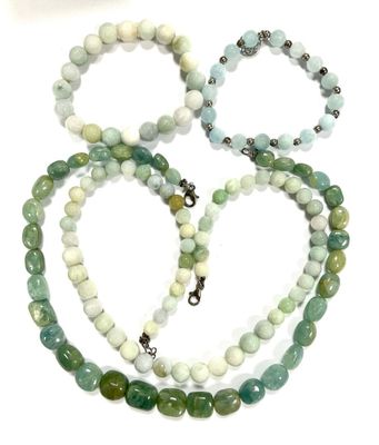 three bracelets with green and white beads on a white surface