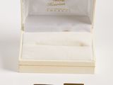 a pair of gold and diamond earrings in a box